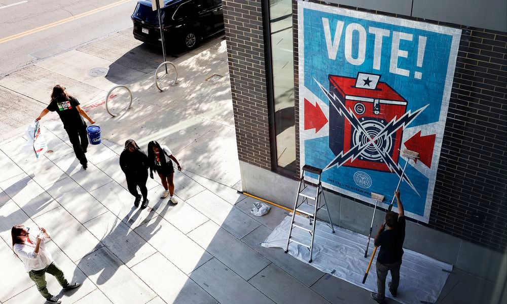 Muralist Shepard Fairey, places a mural Wednesday 18, 2024 on the Dayton Metro Library Downtown. MARSHALL GORBY\STAFF