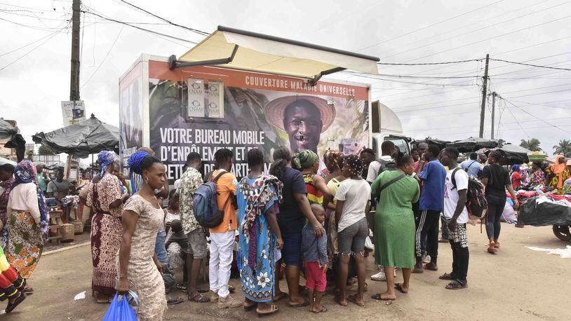 Residents line up in front of a mobile enrolment center from the Ivory Coast health authorities in Abidjan Monday, June 10, 2024. The country's universal health coverage program, has been criticized since its inception in 2019 for an inefficient voucher system that has made it impossible for participants to access the benefits. The mobile enrolment centers allow Ivorians to sign up for the scheme and provide them with cards on site, so that they can start receiving care immediately at hospitals, clinics, and pharmacies around the country. (AP Photo/ Diomande Ble Blonde)