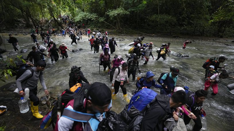 FILE - Migrants cross a river during their journey through the Darien Gap from Colombia into Panama, Oct. 15, 2022. (AP Photo/Fernando Vergara, File)