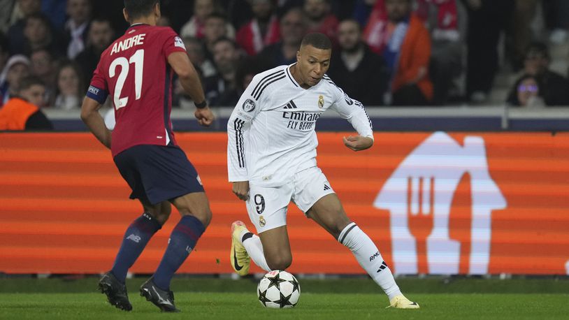 Real Madrid's Kylian Mbappe, right, dribbles the ball past Lille's Benjamin Andre during the Champions League opening phase soccer match between Lille and Real Madrid at the Stade Pierre Mauroy in Villeneuve-d'Ascq, outside Lille, France, Wednesday, Oct. 2, 2024. (AP Photo/Thibault Camus)