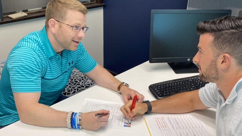 Andrew Nicholls of Coldwell Banker Heritage realty consults with a client. CONTRIBUTED