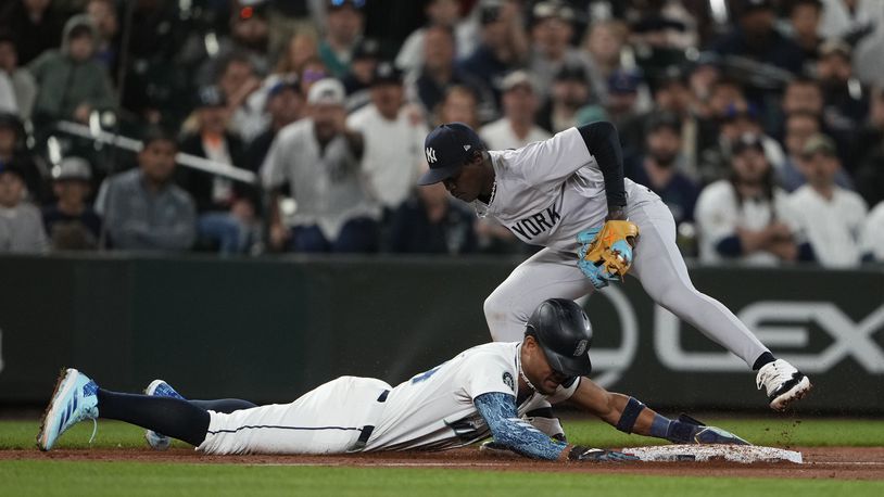 Seattle Mariners' Julio Rodríguez is picked off at third base by New York Yankees third baseman Jazz Chisholm Jr. after Mariners' Randy Arozarena lost his bat on a swing during the 10th inning of a baseball game Wednesday, Sept. 18, 2024, in Seattle. (AP Photo/Lindsey Wasson)