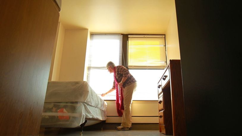 In this file photo, YWCA Rental Manager Cathy Armentrout opened blinds in a vacant room that was to double in size and be used as an efficiency apartment at the downtown Dayton YWCA. The applications for the rehab work were reviewed by the Ohio Housing Finance Agency.