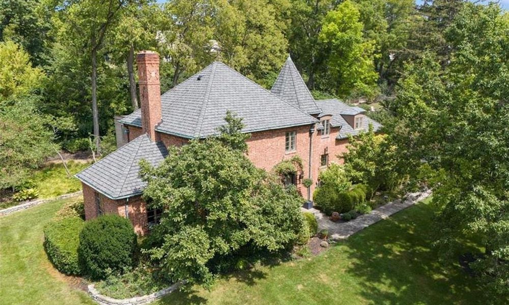 The brick French revival style home has been extensively updated and sits on a wooded lot within walking distance to Oakwood shops and schools