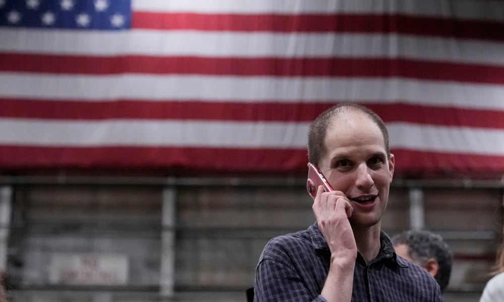 Evan Gershkovich talks on the phone after he arrived at Kelly Field after being released by Russia, Friday, Aug. 2, 2024, in San Antonio. (AP Photo/Eric Gay)