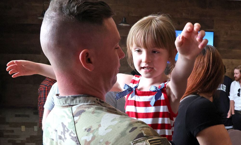 Calliope East gives her father, SSG Jacob East of the Ohio Army National Guard 1137th Tactical Installation Networking Enhanced Signal Company, a hug following a Call to Duty Ceremony for the unit Saturday, August 31, 2024 at the First Christian Church in Springfield. BILL LACKEY/STAFF