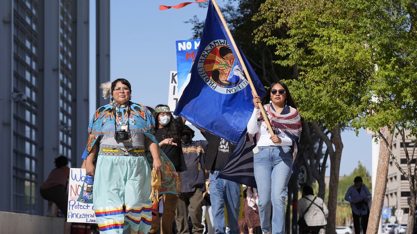 Zoe Perry, left, and Loveena Watahomiegie, right, as they join other members of the Hualapai Tribe while marching in front of U.S. District Court as they gathered to try to persuade a federal judge to extend a temporary ban on exploratory drilling for a lithium project near tribal lands Tuesday, Sept. 17, 2024, in Phoenix. (AP Photo/Ross D. Franklin)