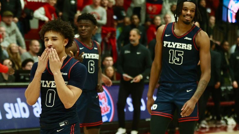 Dayton's Javon Bennett, left, and DaRon Holmes II celebrate a victory against Saint Joseph’s on Tuesday, Feb. 6, 2024, at Hagan Arena in Philadelphia. David Jablonski/Staff