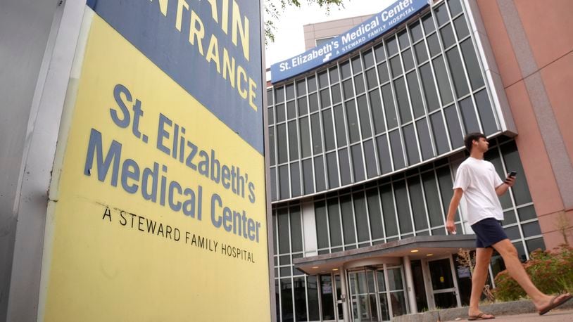 A passer-by walks past an entrance to St. Elizabeth's Medical Center, Thursday, Sept. 19, 2024, in the Brighton neighborhood of Boston. (AP Photo/Steven Senne)