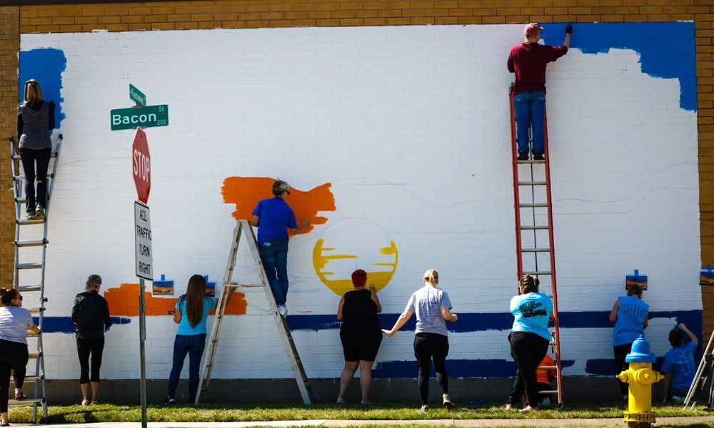 Volunteers from Leadership Dayton Class Project and the ADAMHS Board work on a suicide prevention mural on the Tuffy Brooks Sporting Goods building, located at 101 S. Keowee St. in Dayton. The initiative from the Montgomery County Prevention Coalition to spread messages of hope. The mural will also feature a QR code with a link to mental health resources. JIM NOELKER/STAFF