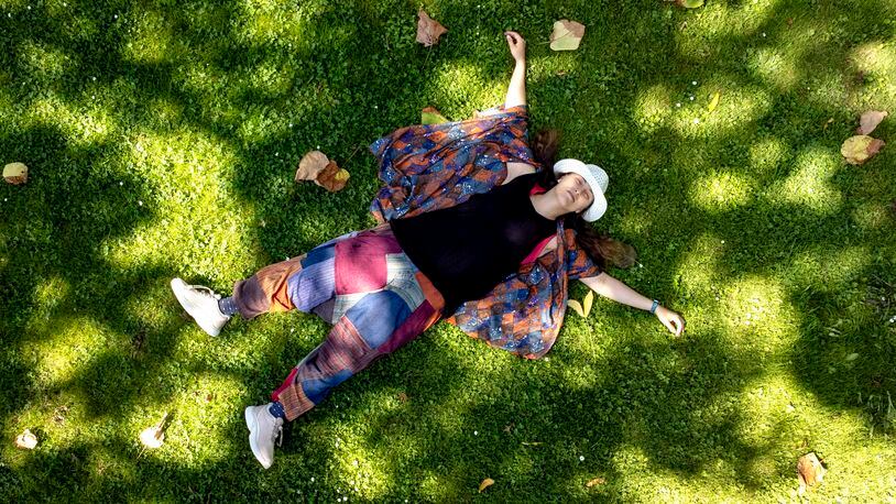 Russian artist Sasha Skochilenko, freed in a prisoner swap this month, relaxes on the grass in a park in Koblenz, Germany, Saturday, Aug. 10, 2024. (AP Photo/Michael Probst)