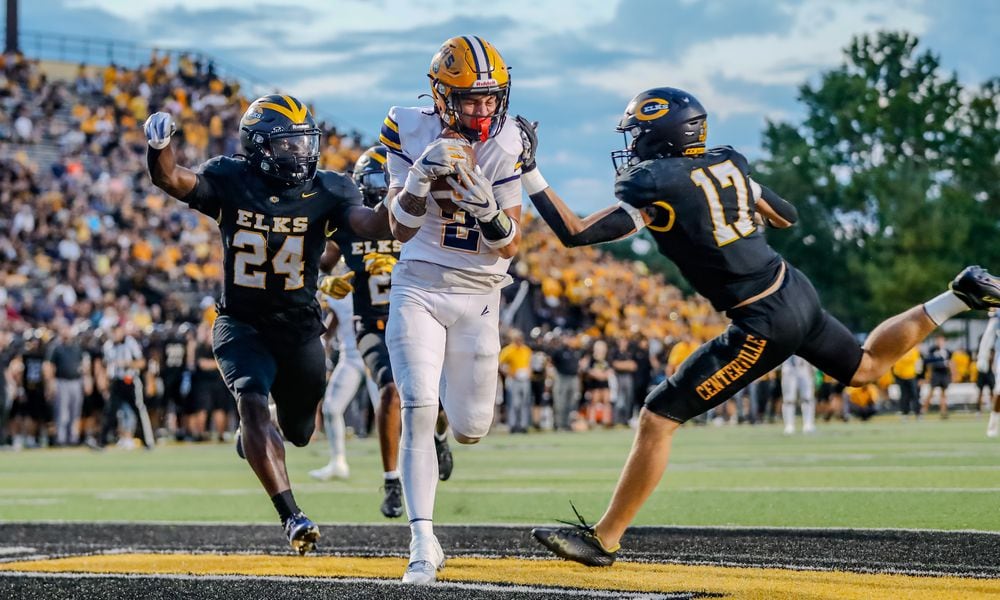 Cutline: Springfield High School senior Bop Wafer catches a touchdown pass between Centerville two defenders during their game on Friday night at Centerville Stadium. The Wildcats won 17-3. Michael Cooper/CONTRIBUTED