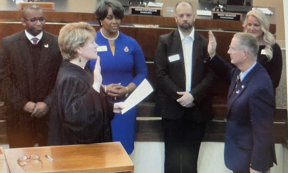 Fairborn Mayor Dan Kirkpatrick (front right) is sworn in Monday night by municipal court Judge Beth Cappelli as city council members look on. NICK BLIZZARD/STAFF