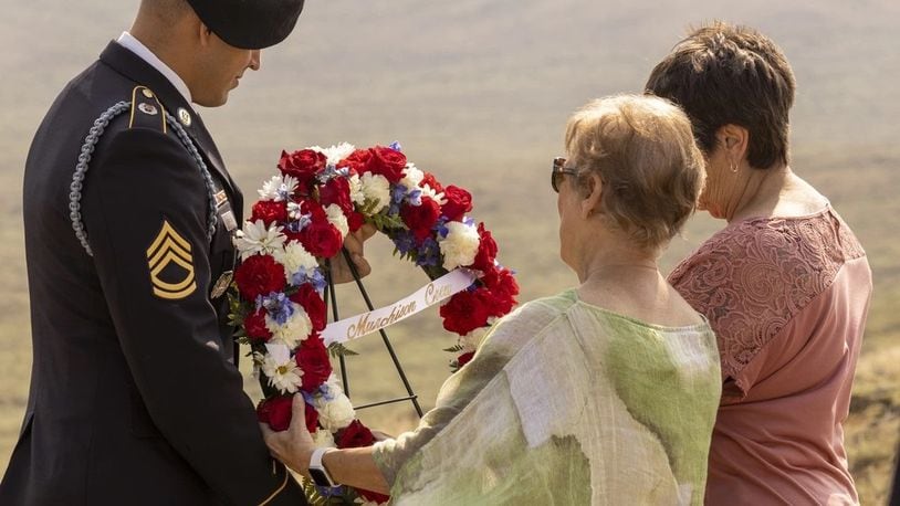 A member of the Wyoming Army National Guard helps the family of the lost crew present a wreath at the memorial service for the crew of Consolidated B-24J Liberator number 42-95559 outside of Casper, Wyo., July 24, 2021. (U.S. Army National Guard photo by Sgt. Stew Dyer)