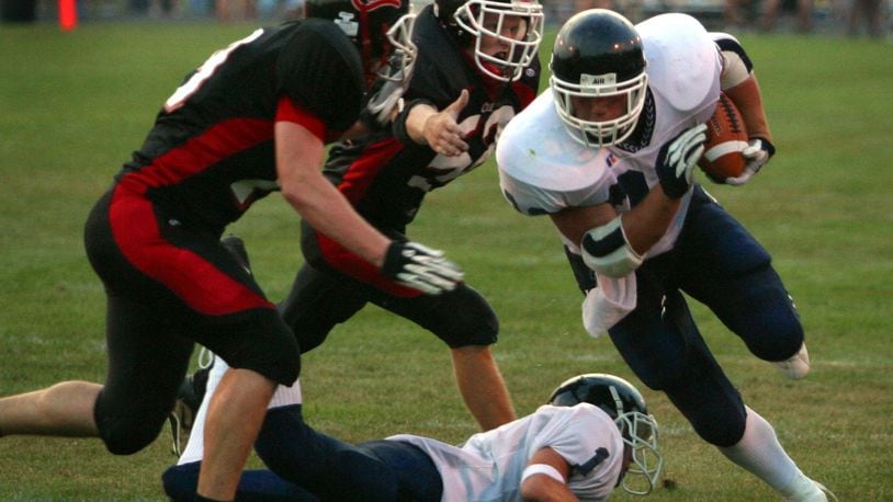 08-23-02 — Valley View Spartans’ Brock Bolen moves the ball as Franklin Wildcats Chris Kaer and Eric Carl move in for the tackle during Franklin’s home opener.