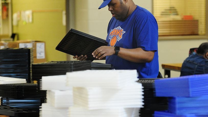 Jorge sorts through plastic trays for shipping, one of his tasks to earn a paycheck through the federal 14 c program. MARSHALL GORBY\STAFF