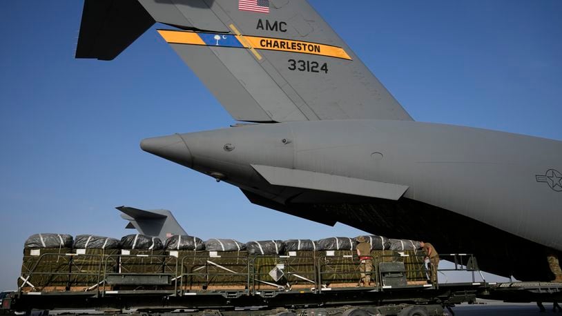 Members of the U.S. Air Force load containers of humanitarian aid into an airplane at Al-Udeid Air Base, Qatar, Friday, March 29, 2024, prior to dropping them over Gaza Strip. (AP Photo/Hussein Malla)