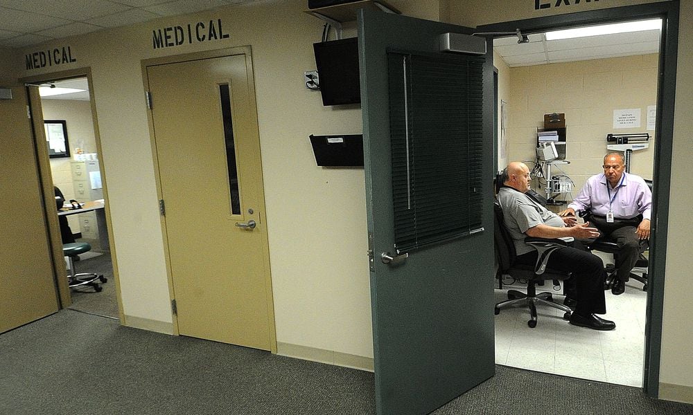 Therapist Larry Stephens (left) and Psychiatrist Esam Alkhawaga (right) discuss patient care at Dr. A's office at the Greene County Jail. MARSHALL GORBY/STAFF