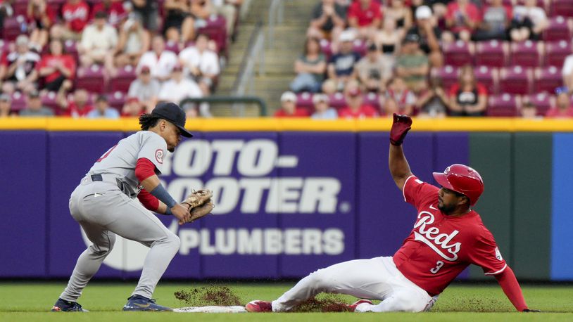 Cincinnati Reds' Jeimer Candelario (3) slides into second base with a double, next to St. Louis Cardinals shortstop Masyn Winn during the sixth inning of a baseball game against the St. Louis Cardinals Tuesday, May 28, 2024, in Cincinnati. (AP Photo/Jeff Dean)
