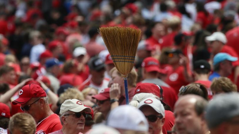 A fan carries a broom after the Reds swept the Rockies on Wednesday, June 21, 2023, at Great American Ball Park in Cincinnati. David Jablonski/Staff