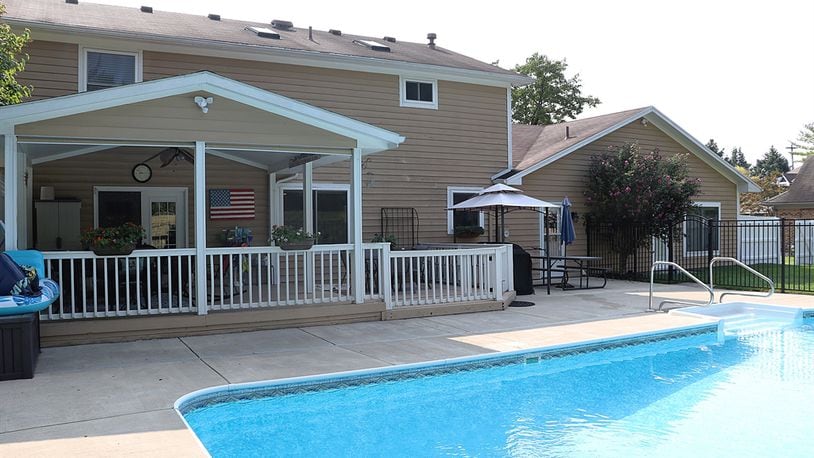 A home for sale at 4141 Abbeygate Drive has a covered outdoor seating area and a swimming pool. CONTRIBUTED