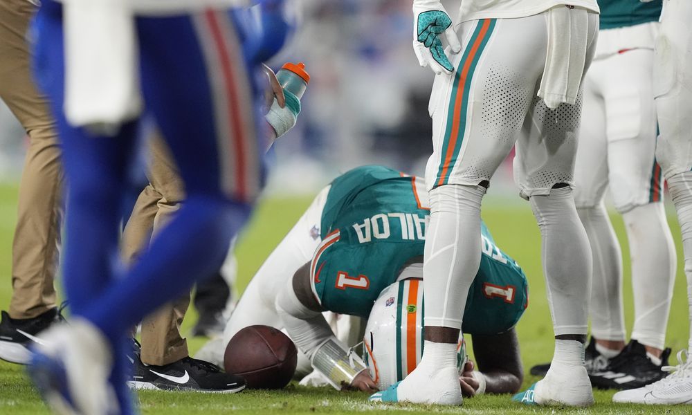 Miami Dolphins quarterback Tua Tagovailoa (1) is assisted on the field during the second half of an NFL football game against the Buffalo Bills, Thursday, Sept. 12, 2024, in Miami Gardens, Fla. (AP Photo/Rebecca Blackwell)