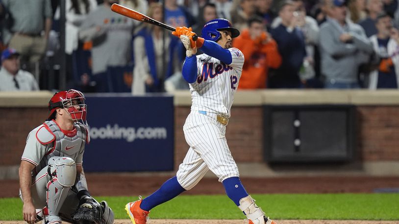 New York Mets' Francisco Lindor (12) follows through on a grand slam home run against the Philadelphia Phillies during the sixth inning of Game 4 of the National League baseball playoff series, Wednesday, Oct. 9, 2024, in New York. (AP Photo/Frank Franklin II)