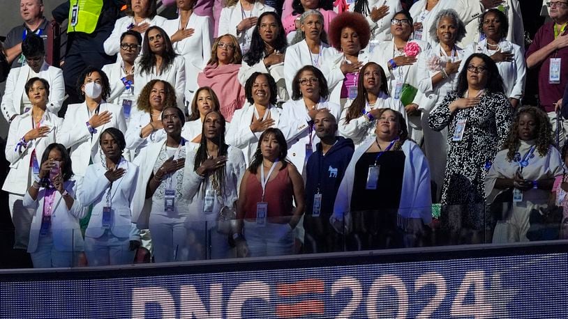 People wear white during the Pleadge of Alliegence during the Democratic National Convention Thursday, Aug. 22, 2024, in Chicago. (AP Photo/Charles Rex Arbogast)