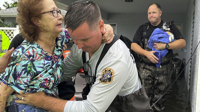 This photo provided by Venice Police Department rescue crews assist residents after conducting door-to-door wellness checks, in coastal areas that were flooded by Hurricane Helene on Friday, Sept. 27, 2024 in Venice, Fla . (Venice Police Department via AP)