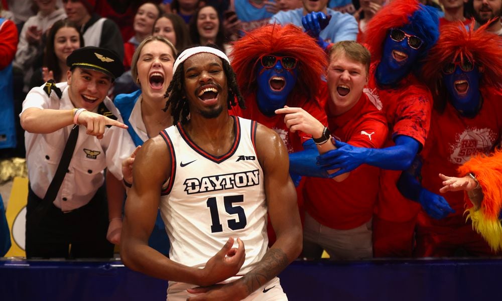 Dayton's DaRon Holmes II celebrates with fans in the Red Scare student section after a victory against Fordham on Saturday, Feb. 17, 2024, at UD Arena. David Jablonski/Staff