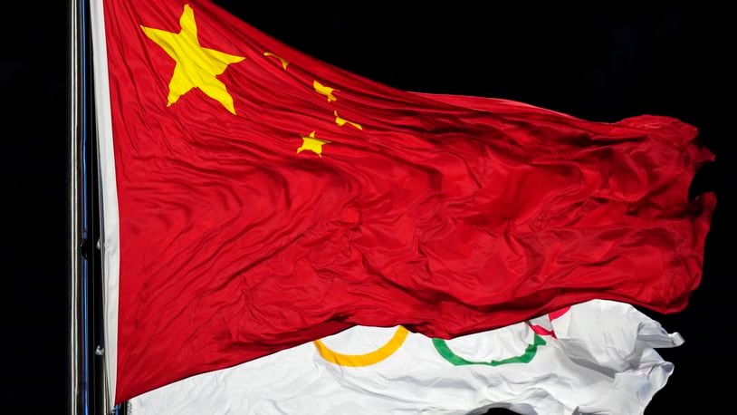 FILE - The Chinese and the Olympic flag wave during the opening ceremony of the 2022 Winter Olympics, Feb. 4, 2022, in Beijing. (AP Photo/Petr David Josek, File)