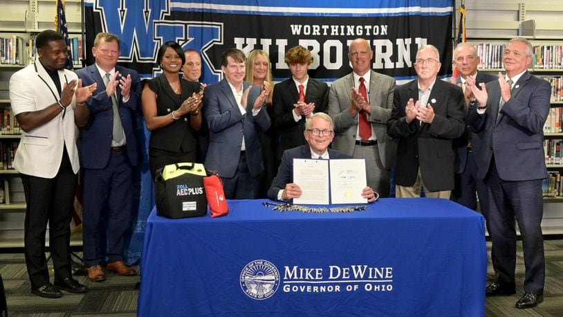 Ohio Gov. Mike DeWine shows off the signed House Bill 47, which will require all public and private schools to have AEDs on site as well as community centers. Contributed