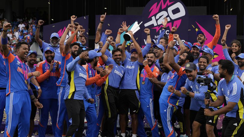 India's head coach Rahul Dravid, center, and players celebrate with the winners trophy after defeating South Africa in the ICC Men's T20 World Cup final cricket match at Kensington Oval in Bridgetown, Barbados, Saturday, June 29, 2024. (AP Photo/Ricardo Mazalan)