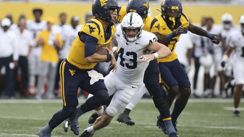 West Virginia quarterback Nicco Marchiol, left, is pressured by Penn State linebacker Tyler Elsdon (43) during the second half of an NCAA college football game in Morgantown, W.Va., Saturday, Aug. 31, 2024. (AP Photo/Kathleen Batten)