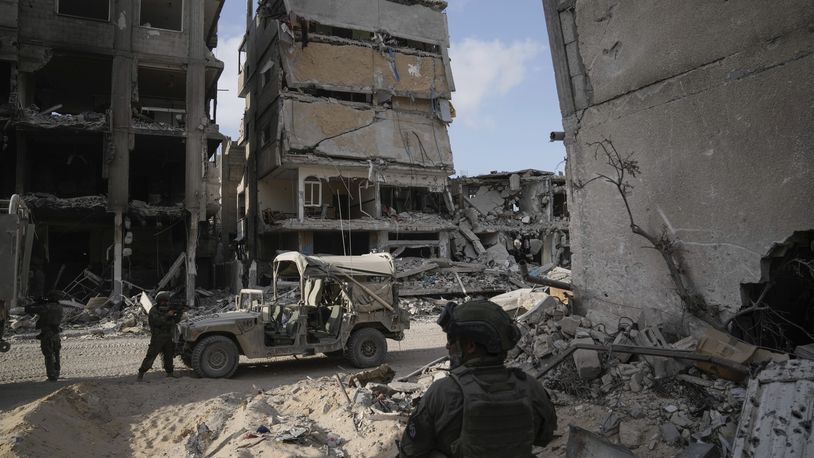 Israeli soldiers take up position next to buildings destroyed by the Israeli military in the Gaza Strip on Friday, Sept. 13, 2024. (AP Photo/Leo Correa)