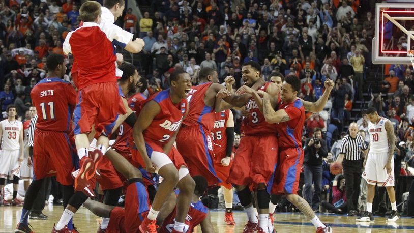 Dayton players celebrate after a 60-59 victory against Ohio State in the second round of the NCAA tournament on Thursday, March 20, 2014, at the First Niagara Center in Buffalo, N.Y. David Jablonski/Staff