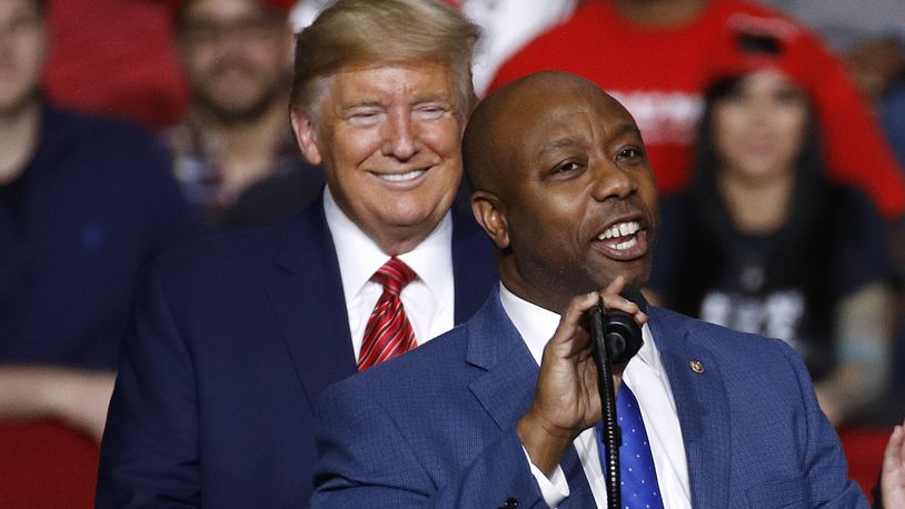 FILE - Sen. Tim Scott, R-S.C., speaks in front of President Donald Trump during a campaign rally, Feb. 28, 2020, in North Charleston, S.C. Scott's life has been a series of people offering a hand that helped him get ahead. Now the senator from South Carolina waits to see if former President Donald Trump gives him another boost and makes him the vice presidential nominee. (AP Photo/Patrick Semansky, File)