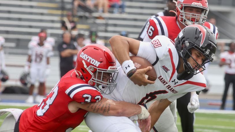 Dayton's Gideon Lampron tackles Nick Whitfield Jr., of St. Francis, on Saturday, Aug. 31, 2024, at Welcome Stadium in Dayton. David Jablonski/Staff