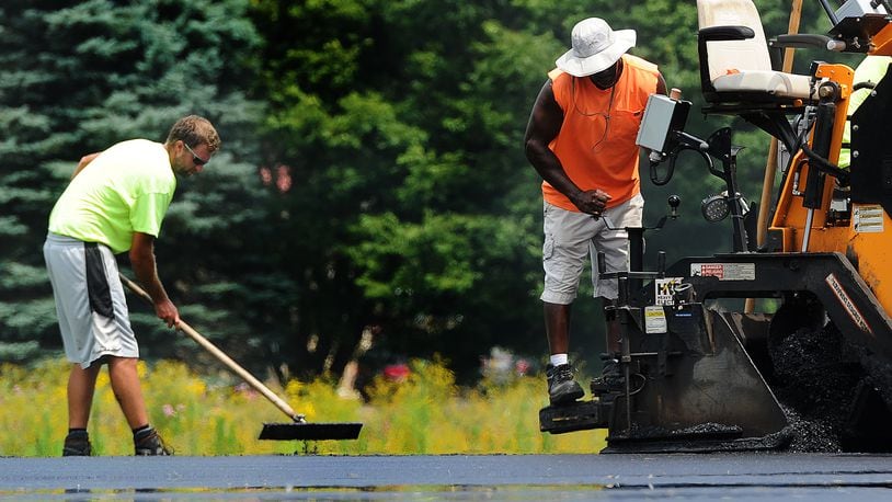 Even with temperatures in the 90s on Wednesday, July 26, 2023, workers were laying asphalt at Thomas A. Cloud Park in Huber Heights. MARSHALL GORBY\STAFF