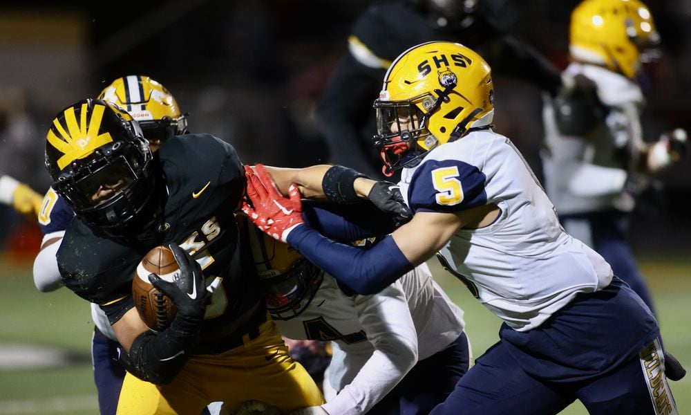 Springfield's Aaron Scott tackles Centerville's Braylon Newcomb in a Division I, Region 2 playoff game on Friday, Nov. 3, 2023, at Centerville. David Jablonski/Staff