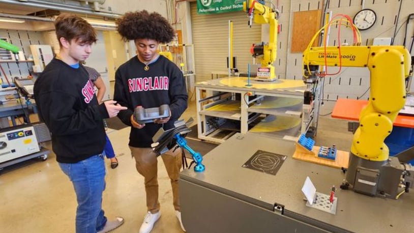 Trent Saylor and LaShawn Crockett tour the robotics lab at Sinclair Community College. Saylor and Crockett are apprentices earning an Associate's Degree in Automation & Control Technology with Robotics from Sinclair, while simultaneously gaining hands-on manufacturing experience at United Grinding North America. SINCLAIR/CONTRIBUTED