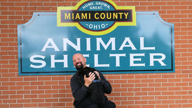 Rob Craft talks about changes at the Miami Count Animal Shelter while accompanied by one of the dogs available for adoption. CONTRIBUTED