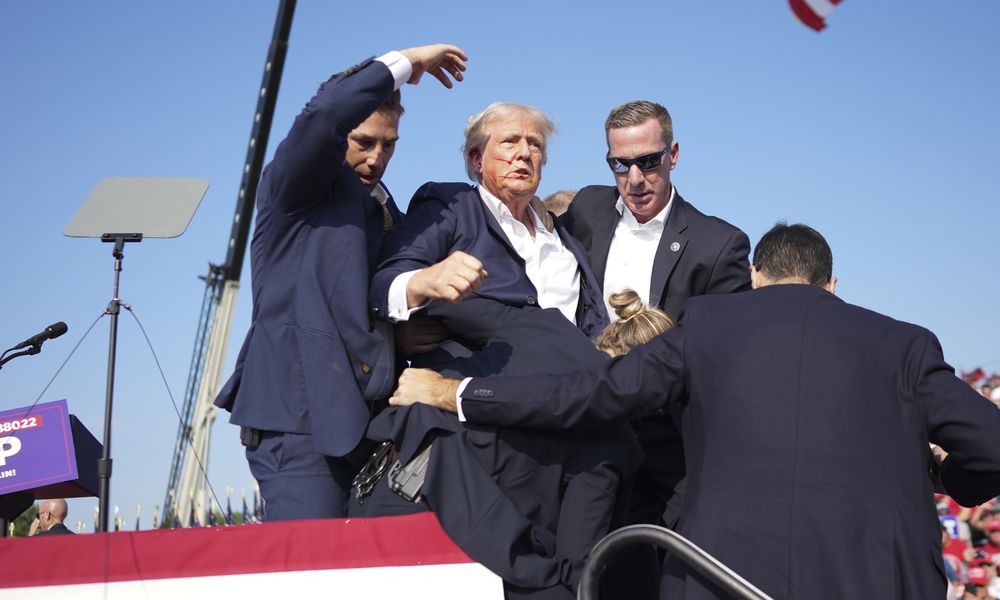  Former President Donald Trump is surrounded by Secret Service agents at a campaign rally in Butler, Pa, on Saturday, July, 13, 2024. Trump was rushed off stage at rally after sounds like shots; the former president was escorted into his motorcade at his rally in Butler, Pa., a rural town about an hour north of Pittsburgh. (Doug Mills/The New York Times) 