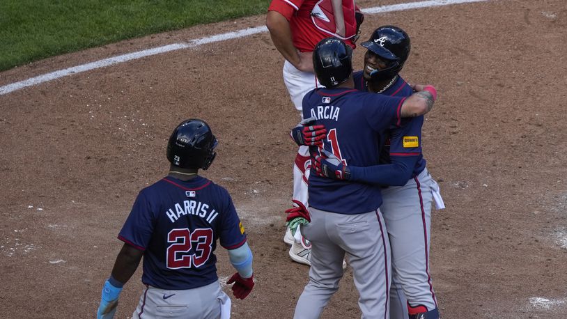 Atlanta Braves' Jorge Soler, right, embraces teammate Orlando Arcia, center, after hitting a 3-run home run during the sixth inning of a baseball game against the Cincinnati Reds, Thursday, Sept. 19, 2024, in Cincinnati. (AP Photo/Joshua A. Bickel)