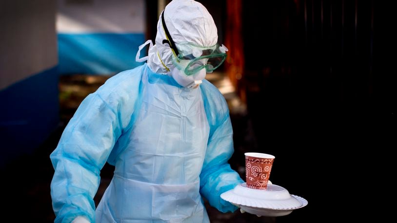 FILE - In this Oct. 8, 2014 photo, a medical worker from the Infection Prevention and Control unit wearing full protective equipment carries a meal to an isolation tent housing a man being quarantined after coming into contact in Uganda with a carrier of the Marburg Virus, at the Kenyatta National Hospital in Nairobi, Kenya. (AP Photo/Ben Curtis, File)