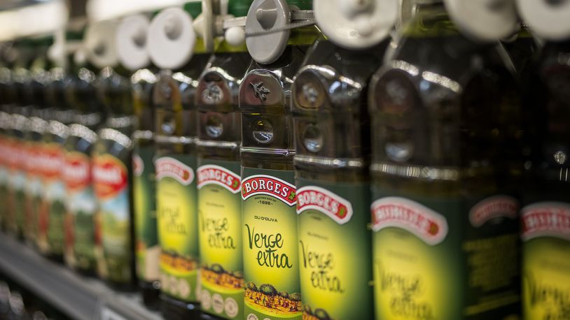 Bottles of virgin olive oil, sealed with an anti-theft system, are photographed on a shelf in a shop in Barcelona, Spain, Tuesday, June 25, 2024. Spain will temporarily eliminate sales tax on olive oil to help consumers cope with skyrocketing prices, the government said Tuesday. (AP Photo/Emilio Morenatti)