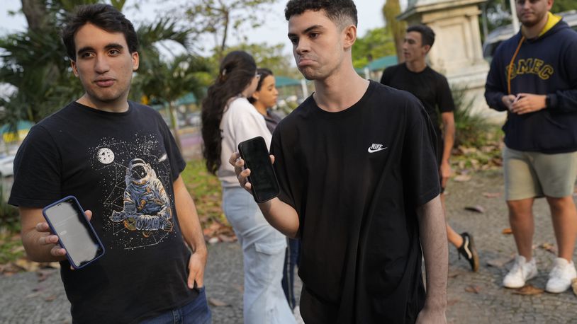 University students show their phone screens after social media platform X was blocked nationwide, in Rio de Janeiro, Monday, Sept. 2, 2024. (AP Photo/Silvia Izquierdo)