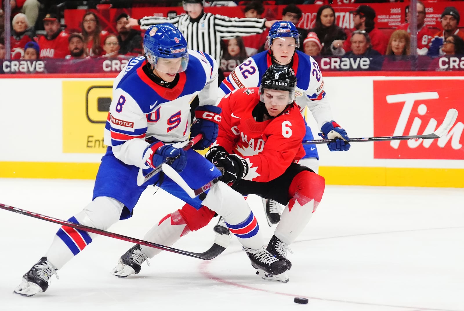 United States' Brandon Svoboda (8) and Canada's Tanner Molendyk (6) battle for the puck during the third period of an IIHF World Junior Hockey Championship tournament game in Ottawa, Ontario on Tuesday, Dec. 31, 2024. (Sean Kilpatrick/The Canadian Press via AP)