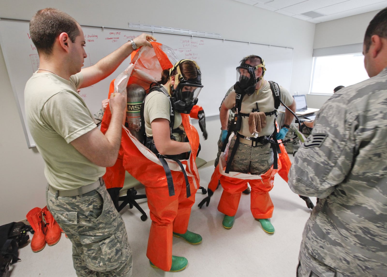 Students at the U.S. Air Force School of Aerospace Medicine practice hazardous materials scenarios in the apprentice program. This class included national guard, and active duty personnel. L-R A1C Jane Vierzen and A1C James Mainolfi wore full hazmat suits with respirators to complete their site reconnaissance health risk assessment training. —Staff Photo by Ty Greenlees