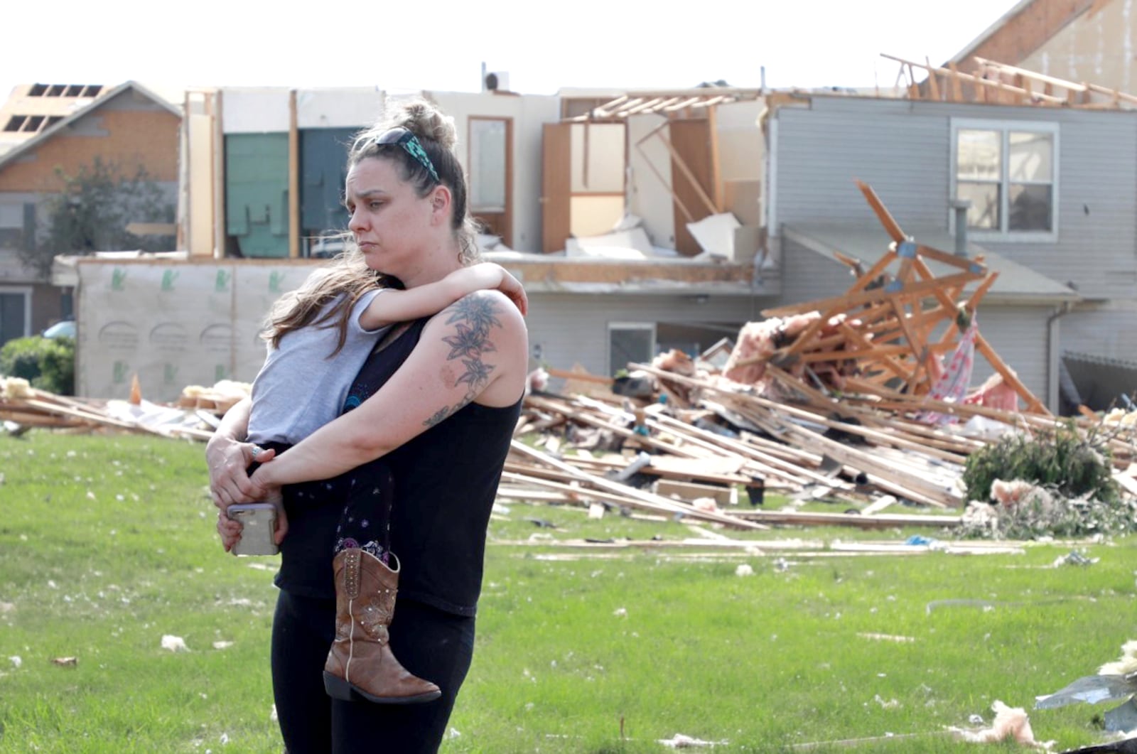 Meghan Porter and daughter Gemma,6, of Beavercreek stand in front of a damaged apartment complex. Porter said her childhood home in Beavercreek was destroyed. BILL LACKEY/STAFF PHOTOGRAPHER